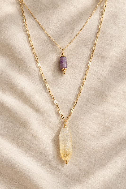 sautoir plaqué or et citrine avec ras du cou plaqué or et améthyste sur fond beige